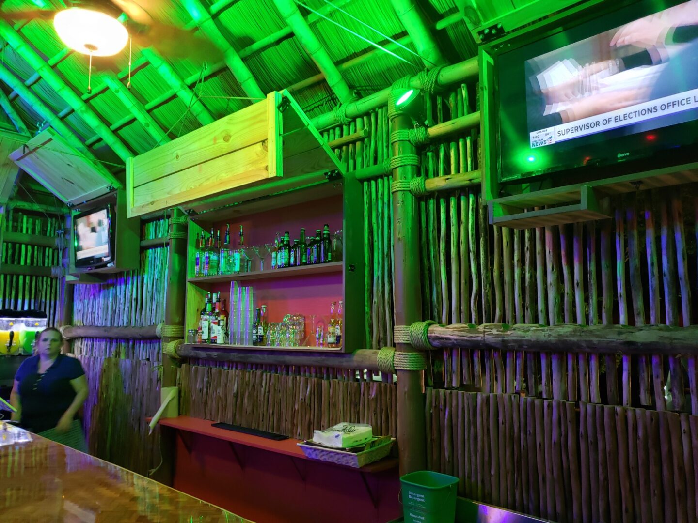 A tiki bar and hut with green lights