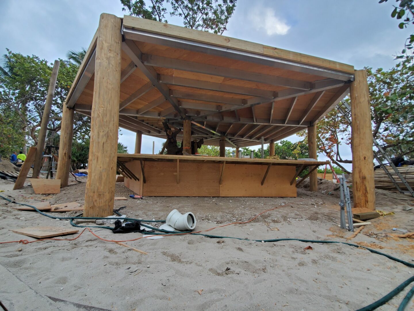 A wooden gazebo is being built on the beach.
