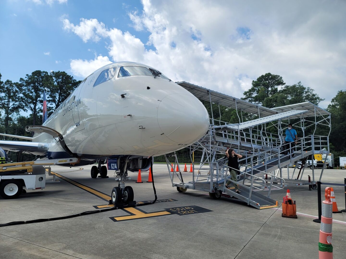 A white airplane parked on the tarmac.