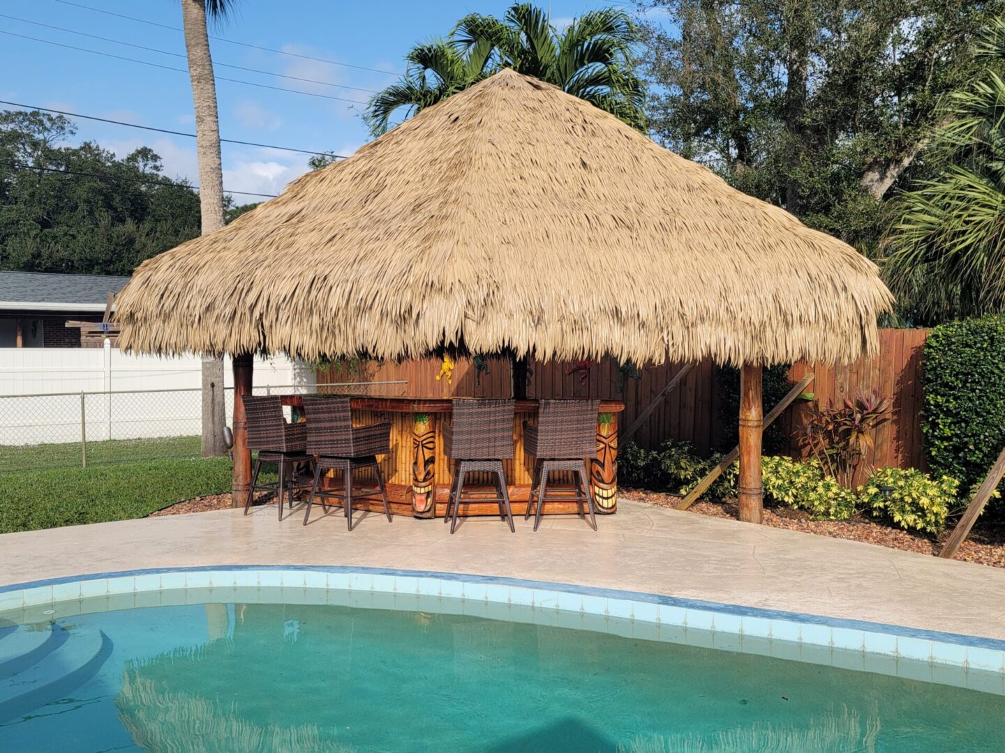 A tiki hut next to a pool.