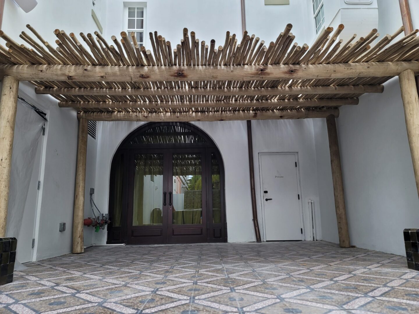The entrance to a house with a wooden pergola.