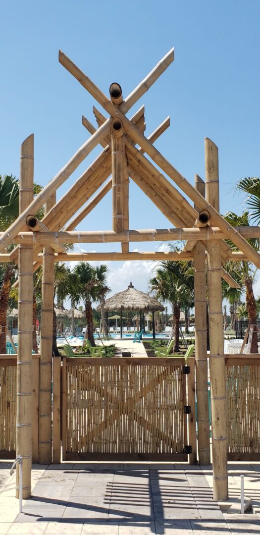 A wooden gazebo with a palm tree in the background.