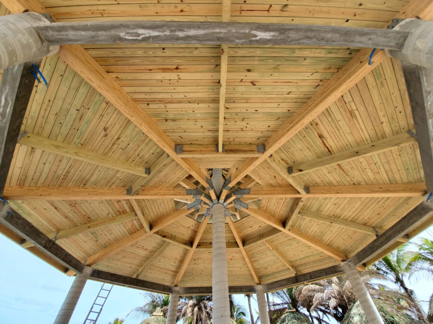 The ceiling of a wooden gazebo is being built.