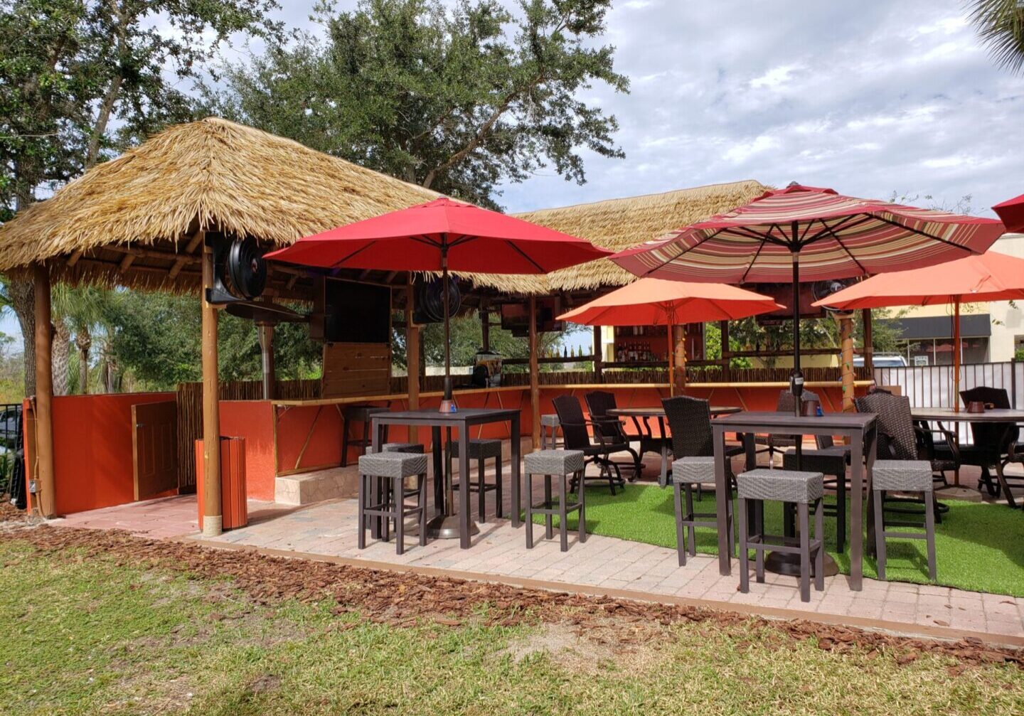 A tiki hut and bar with tables and chairs