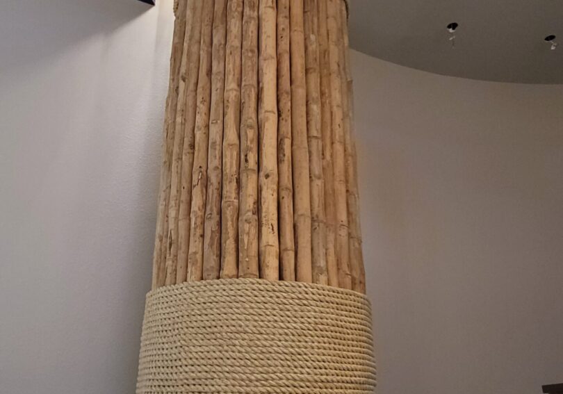 A wooden column with a rope around it.