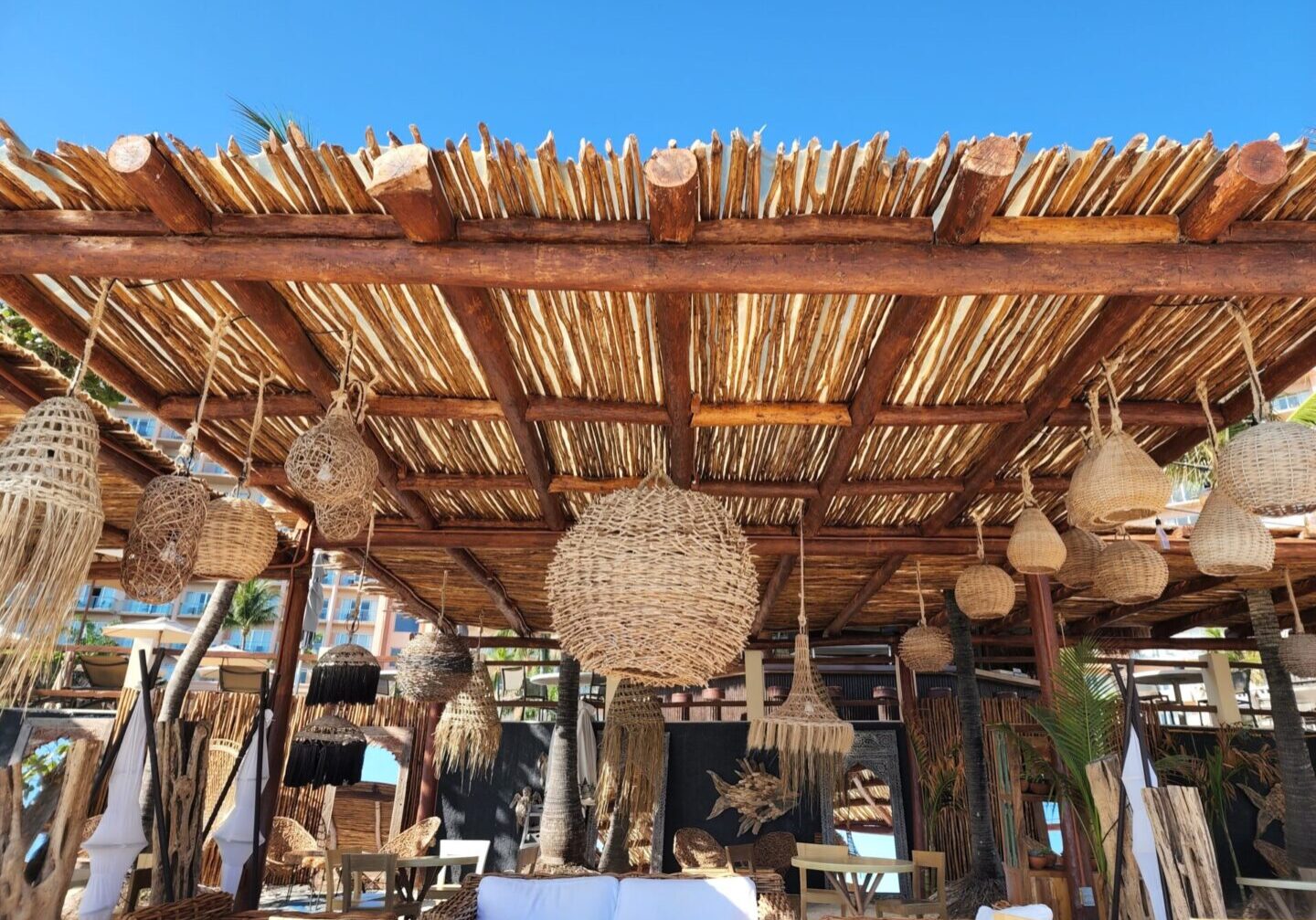 A restaurant with a wooden roof and hanging baskets.
