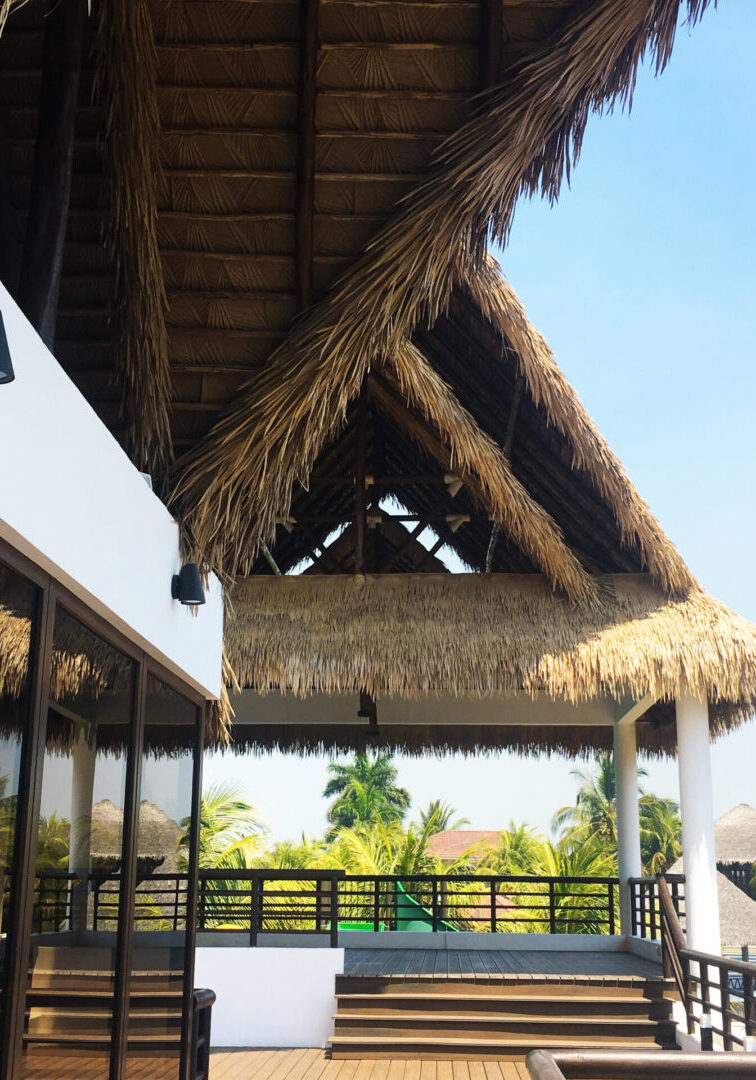 A wooden deck with a thatched roof.
