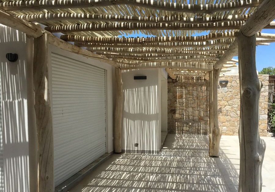 A wooden pergola with a garage attached to it.