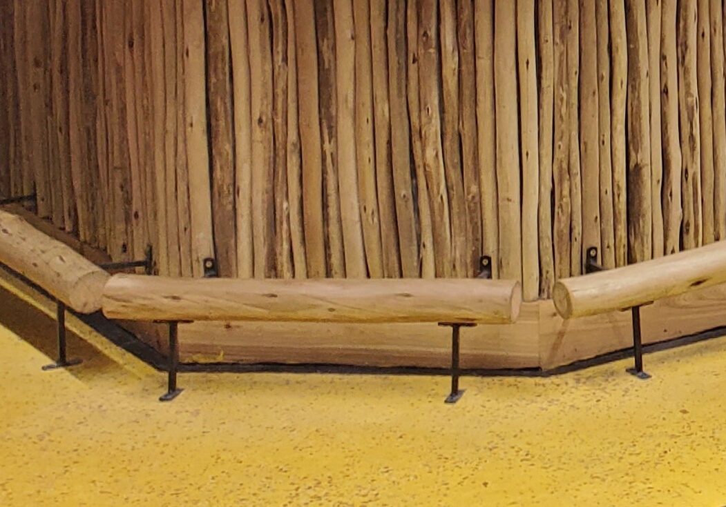 A wooden bench with a yellow floor next to it.